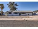Single-story home with desert landscaping, neutral color palette, and an attached garage at 1718 W Voltaire Ave, Phoenix, AZ 85029