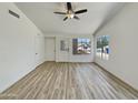 Spacious living room features wood-look flooring, white walls and ample natural light from multiple windows at 1739 E Carter Rd, Phoenix, AZ 85042