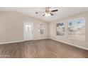 Bright living room with wood-look flooring, neutral paint, ceiling fan, and plenty of natural light at 201 S Greenfield Rd # 29, Mesa, AZ 85206