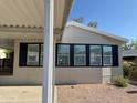 Close-up shot of home with three windows trimmed with black shutters at 2233 E Behrend Dr # 29, Phoenix, AZ 85024