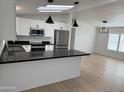 Bright open kitchen with black countertops, white cabinets, and stainless steel appliances at 2233 E Behrend Dr # 29, Phoenix, AZ 85024