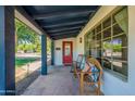 A close-up of the front porch with seating and a bright red door adding character to the home at 317 E Orange Dr, Phoenix, AZ 85012
