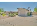 A suburban home showcasing a spacious driveway and well-maintained desert landscaping at 3201 W Mohawk Ln, Phoenix, AZ 85027