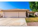 Charming single-story home with a three-car garage, tiled roof, and a well-maintained front yard at 3412 E Kristal Way, Phoenix, AZ 85050