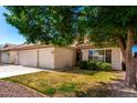 Charming single-story home with a three-car garage, tiled roof, and a well-maintained front yard at 3412 E Kristal Way, Phoenix, AZ 85050