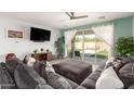 Bright living room with a large sectional, light wood floors and sliding doors opening to the outdoor space at 3415 S 75Th Dr, Phoenix, AZ 85043