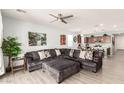 Spacious living room and kitchen area featuring a large sectional sofa, modern lighting and open floor plan at 3415 S 75Th Dr, Phoenix, AZ 85043