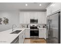 Modern kitchen featuring stainless steel appliances, white cabinets, and wood flooring at 4157 E Pinto Dr, Gilbert, AZ 85296