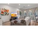 Bright living room featuring wood floors, a TV, modern decor, and balcony access at 4157 E Pinto Dr, Gilbert, AZ 85296