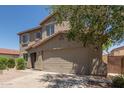 Two-story house featuring a tile roof, desert landscaping, and a two-car garage at 43670 W Mcclelland Ct, Maricopa, AZ 85138