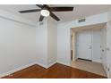 Bright bedroom featuring a ceiling fan, hardwood floors, and ensuite bathroom access at 581 S Roosevelt St, Tempe, AZ 85281