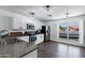 Bright kitchen with stainless steel appliances, a granite countertop, and a window with a view at 5841 W Kesler St, Chandler, AZ 85226
