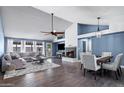 Open concept living room featuring high vaulted ceilings, fireplace, dining area, and large windows at 5841 W Kesler St, Chandler, AZ 85226