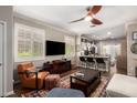 Inviting living room featuring stylish decor, wood floors, plantation shutters and seamless kitchen access at 963 S Colonial Dr, Gilbert, AZ 85296