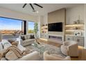 Cozy living room with neutral colors, view to the outside, fireplace and a TV at 13631 E Windrose Dr, Scottsdale, AZ 85259