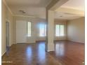 Spacious living room featuring wood and tile floors, crown molding, and lots of natural light at 1390 E Jasper Dr, Gilbert, AZ 85296
