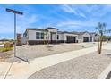Well-manicured single-story home with desert landscaping and a spacious driveway leading to a two-car garage at 15349 W Cottontail Ln, Surprise, AZ 85387