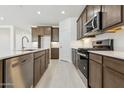 Gourmet kitchen with stainless steel appliances, wood cabinets, and quartz countertops at 15429 W Cottontail Ln, Surprise, AZ 85387