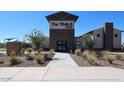 The front entry to the community clubhouse is landscaped with native grasses and shrubbery at 19195 N Los Gabrieles Way, Maricopa, AZ 85138