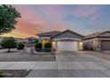 Charming home with desert landscaping, a tiled roof, and a two-car garage at sunset at 20858 E Sonoqui Dr, Queen Creek, AZ 85142