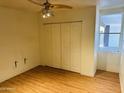 Spacious bedroom features wood-look floors, a lighted ceiling fan, and a window with a view to the outside at 2103 W Missouri Ave, Phoenix, AZ 85015