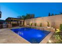 Inviting backyard with pool, waterfall feature, pergola with lighting and travertine pavers at 31311 N 138Th Ave, Peoria, AZ 85383