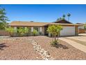 Single-story home with desert landscaping and a two-car garage at 3747 W Aire Libre Ave, Phoenix, AZ 85053