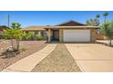 Single-story brick home with a two-car garage and desert landscaping at 3747 W Aire Libre Ave, Phoenix, AZ 85053