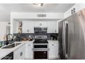 Updated kitchen featuring white cabinets with dark hardware, stainless appliances, and granite countertops at 3829 W Camino Del Rio --, Glendale, AZ 85310