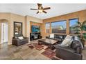 Cozy living room featuring tile flooring, comfortable leather seating, a ceiling fan, and a stone fireplace at 4821 E Kirkland Rd, Phoenix, AZ 85054