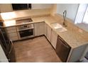 Bright kitchen with granite countertops, stainless steel appliances, white cabinetry, and hardwood floors at 5720 S 21St Ter, Phoenix, AZ 85040