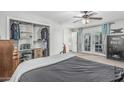 Bright bedroom with plush carpet, a ceiling fan, and a closet with ample storage space at 591 N Cheri Lynn Dr, Chandler, AZ 85225