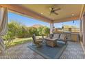 Relaxing covered patio featuring outdoor furniture, a grill, and lush landscaping overlooking the mountain at 6948 E Quill St, Mesa, AZ 85207