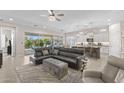 Open living room concept with a large sectional sofa, a view of the kitchen, and sliding glass doors at 6948 E Quill St, Mesa, AZ 85207