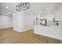 Spacious living room featuring wood-look flooring, modern lighting, and seamlessly connected to the kitchen at 7601 E Roosevelt St # 1012, Scottsdale, AZ 85257