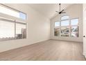 Spacious living room with a vaulted ceiling, modern flooring, and ample natural light at 8928 E Crescent Ave, Mesa, AZ 85208