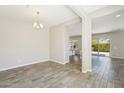 Open dining room with wood-look tile flooring and modern chandelier at 10158 W Angels Ln, Peoria, AZ 85383