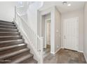 Foyer with staircase, wood-look tile floor, and access to additional rooms at 10158 W Angels Ln, Peoria, AZ 85383