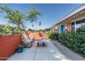 Inviting outdoor patio with seating area, colorful wall, and lush greenery at 1027 E El Camino Dr, Phoenix, AZ 85020
