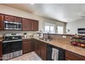 Well-equipped kitchen with dark wood cabinets and modern stainless steel appliances at 13585 N 87Th Dr, Peoria, AZ 85381