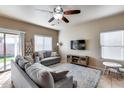 Inviting living room with modern ceiling fan, plush seating, and natural light at 13585 N 87Th Dr, Peoria, AZ 85381