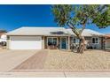Charming single-story home featuring a well-maintained lawn, a blue front door, and a two car garage at 18233 N 55Th Dr, Glendale, AZ 85308