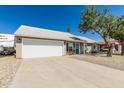 Inviting single-story home with a two-car garage, appealing front yard, and a blue front door at 18233 N 55Th Dr, Glendale, AZ 85308