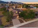 Aerial view of the property, showcasing mountain views and neighborhood homes at sunset at 1834 W Nighthawk Way, Phoenix, AZ 85045
