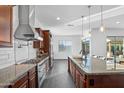 Spacious kitchen featuring wooden cabinets, granite countertops, stainless steel appliances, and a large center island at 18544 W Devonshire Ave, Goodyear, AZ 85395