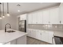 Bright kitchen featuring white cabinets, stainless steel appliances, and grey backsplash at 18773 E Panchito Dr, Gold Canyon, AZ 85118