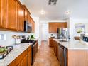 Well-equipped kitchen featuring wooden cabinets, granite countertops, stainless steel appliances, and ample counter space at 19403 E Arrowhead Trl, Queen Creek, AZ 85142
