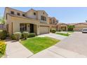 Inviting two-story home with a two-car garage, lush lawn, and beautiful desert landscaping and an arched entryway at 2043 W Periwinkle Way, Chandler, AZ 85248