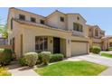 Inviting two-story home with a two-car garage, lush lawn, and beautiful desert landscaping and an arched entryway at 2043 W Periwinkle Way, Chandler, AZ 85248