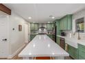 Kitchen showcases custom green cabinets, stainless appliances, a white backsplash, and a large center island at 2402 E Cinnabar Ave, Phoenix, AZ 85028